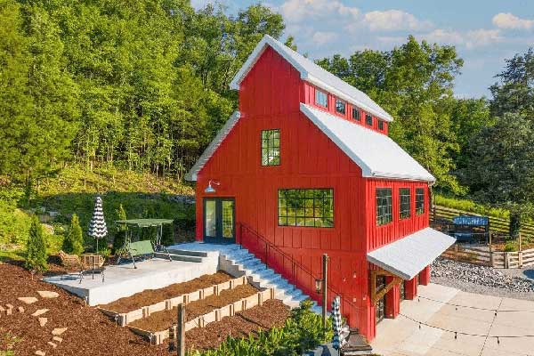 Newly built red barndominium with a white roof