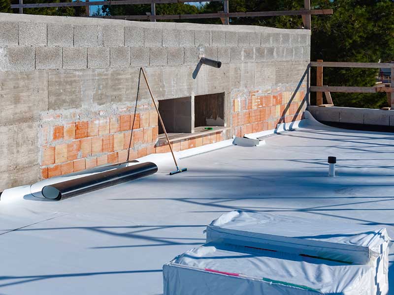 Small commercial roof getting a new white roof membrane installed