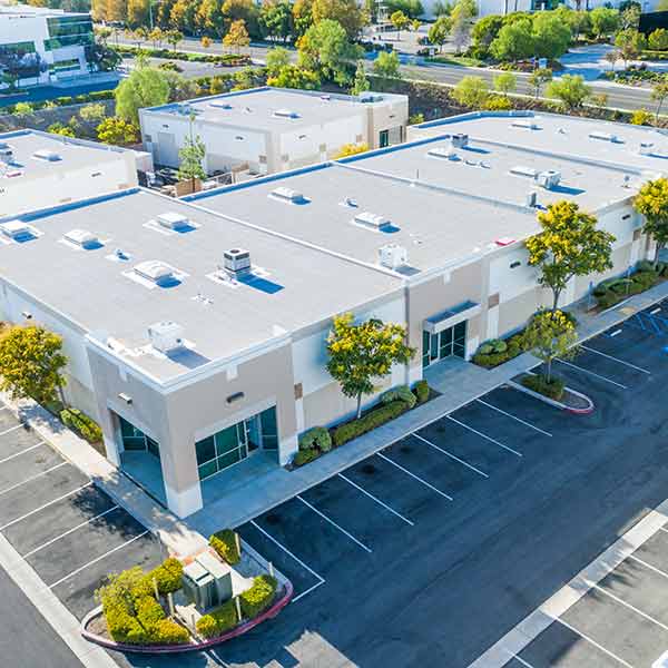 Ariel view of a large, modern commercial building with a white, flat roof
